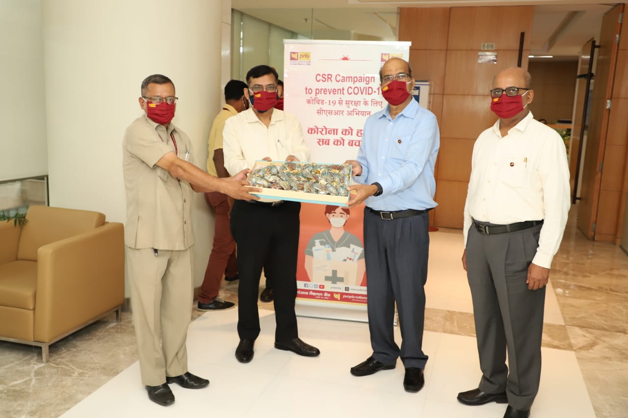 Dr. Rajesh Kumar Yaduvanshi, Shri Sanjay Kumar and Shri Vijay Dube distributing prevention materials to the facility management staff at the PNB Head office, New Delhi -Photo By GPN